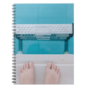 Persoon die op de zwembadladder staat notitieboek