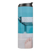 Persoon die op de zwembadladder staat thermosbeker (Gedraaid links)