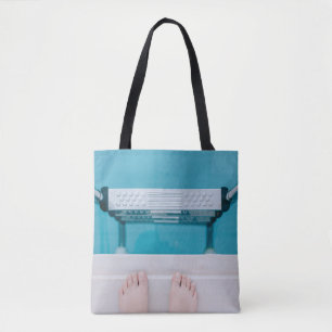 Persoon die op de zwembadladder staat tote bag