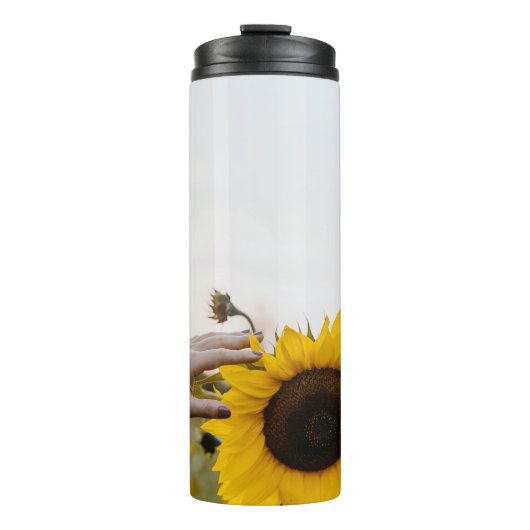 Persoon die zonnebloem houdt thermosbeker (Voorkant)