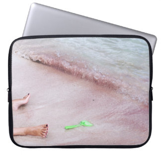 Persoon voet naast groene schop op zee laptop sleeve