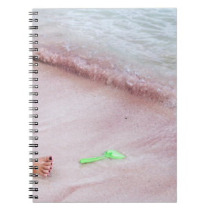 Persoon voet naast groene schop op zee notitieboek