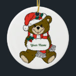 Persoonlijke teeddy Bear-kerstversiering Keramisch Ornament<br><div class="desc">Deze teddybeer is allemaal gekleed voor Kerstmis met zijn kerstman en rode en witte sjaal. Dit is een cool cadeauidee voor iedereen die van teddyberen houdt (en er zijn veel mensen die dat doen!) - voeg hun naam toe aan het teken dat Santa Teddy houdt en je hebt een geweldig...</div>