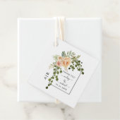 Perzikkoraalbloemen, boog en bruiloft op monogram bedankjes labels (In situ)