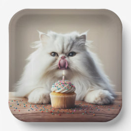 Perzische kat likt een verjaardagscupcake papieren bordje