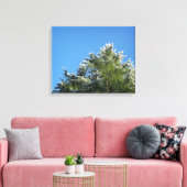 Pijnboom met sneeuwklemmen op blauwe hemel canvas afdruk (Insitu (Woonkamer))