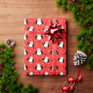 Pinguïns in kerststemming op rood  cadeaupapier