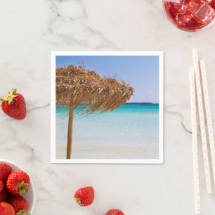 Pittoresk tropisch strand met strooien parasol servet