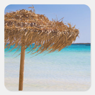 Pittoresk tropisch strand met strooien parasol vierkante sticker