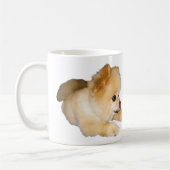 Pommerse hond die tong uit tikt koffiemok (Links)