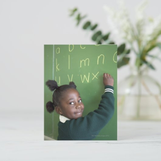 Portret van glimlachend schoolmeisje dat op de briefkaart (Staand voorkant)