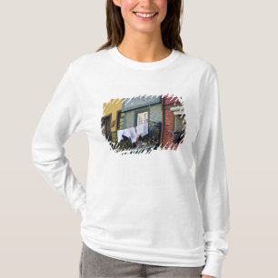Portugal, Oporto (Porto). Vrouw hangt wasgoed T-shirt