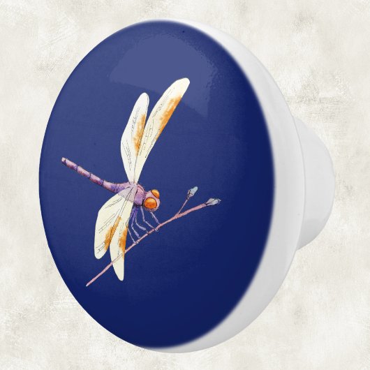 Prachtige libel op tak op donkerblauw keramische knop