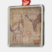 Prehistorische rotsschilderijen met kamelen en metalen ornament (Links)