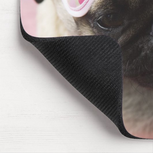 Pug hond met oogmasker op het hoofd dat op bed zit muismat (Hoek)