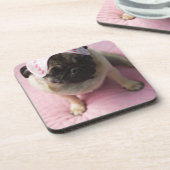 Pug hond met oogmasker op het hoofd dat op bed zit onderzetter (Linkerzijde)