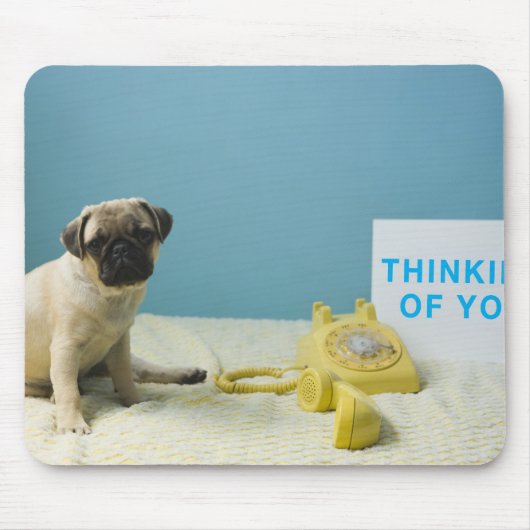 Pug puppy op bed naast de telefoon en muismat (Voorkant)