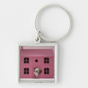 Puppy peering uit het huis van de pop sleutelhanger