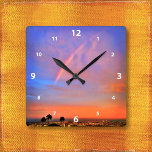 Rainbow oranje blue sunset sky landscape foto vierkante klok<br><div class="desc">Erken de schoonheid van de natuur wanneer je de tijd op deze fotografische wandklok bekijkt van een regenboog die in een blauwe, roze en oranje, zacht verlichte zonsondergang is genaderd. Uw keuze uit een rond of vierkant klokgezicht. Maakt een geweldig cadeau voor het huishouden! U kunt deze muurklok eenvoudig personaliseren...</div>