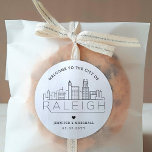 Raleigh Wedding | Welkom Favor Ronde Sticker<br><div class="desc">Verbeter uw huwelijksonthaalpakketten of de gunsten van de gebeurtenispartij met een douaneset van welkomststickers! Deze elegante maar toch minimalistische stickers zijn op maat gemaakt voor een bruiloft die plaatsvindt in de prachtige stad Raleigh, North Carolina. Ze hebben een moderne skyline met de naam van de stad eronder geïntegreerd. Alle elementen...</div>