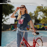 Red Jam of Jelly Jar Custom Bericht Grafisch T-shirt<br><div class="desc">Voeg een grappige slogan of een gepersonaliseerde boodschap toe aan creëer uw eigen aangepaste grafische t-shirt. Uw bericht wordt weergegeven in vetgedrukte crèmekleurige letters boven een afbeelding van een jampot. De pot is gevuld met een donkerrode vruchtenjam en heeft een crème en blauwe gingham geplakt deksel. De illustratie heeft een...</div>