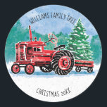 Red Vintage Tractor Christmas Tree Voeg naam toe Ronde Sticker<br><div class="desc">Deze sticker is voorzien van een rode tractor die een kerstboom in een wagen erachter trekt met een winterscène met sneeuw en bomen erachter. Het bericht luidt "Williams Family Tree". Personaliseer met je eigen naam, Onder de tractor staat "Christmas 20xx". Voeg het juiste jaar toe bij het personaliseren. Ontworpen door...</div>