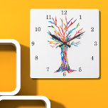 Regenboogboomklokklok Vierkante Klok<br><div class="desc">Deze witte klok is versierd met een afdruk van een ontwerp van de Levensboom in regenboogkleuren. De boom werd oorspronkelijk in mozaïek gemaakt met kleine fragmenten van helder gekleurd glas. Omdat we ons eigen kunstwerk creëer, zal je dit exacte afbeelding niet vinden van andere ontwerpers. Originele mozaïek © Michele Davies....</div>