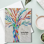 Regenboogkleurige levensboom planner<br><div class="desc">Deze bijzondere Planner is versierd met een regenboogkleurige Tree of Life mozaïek op een bleke grijze achtergrond. Het oorspronkelijke ontwerp werd gemaakt met behulp van kleine stukjes helder gekleurd glas. Pas het aan met jouw naam en jaar. Origineel mozaïek © Michele Davies.</div>