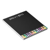 Regenboogpianotoetsen op zwart notitieblok (Schuin)