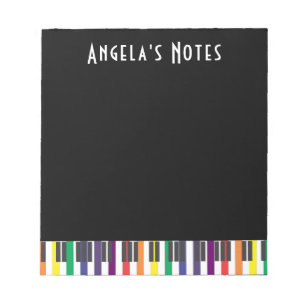 Regenboogpianotoetsen op zwart notitieblok