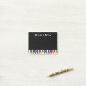 Regenboogpianotoetsen op zwart post-it® notes (Op bureau)