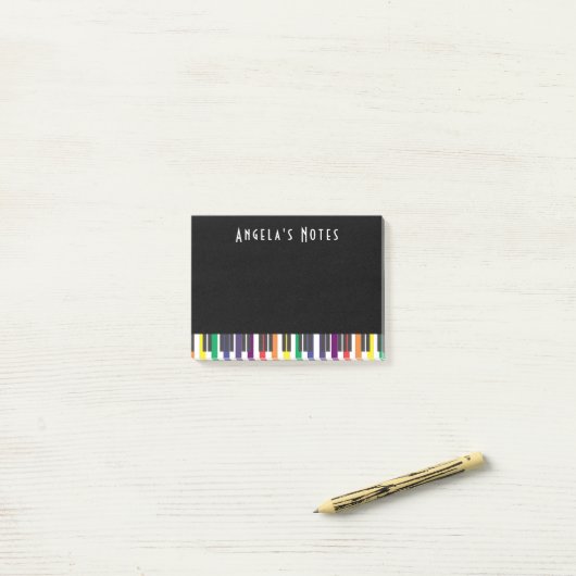 Regenboogpianotoetsen op zwart post-it® notes (Op bureau)