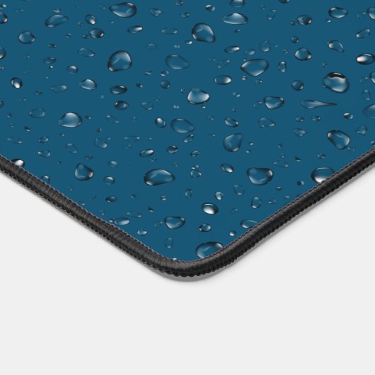 regendruppels op blauw bureaumat (Hoek)