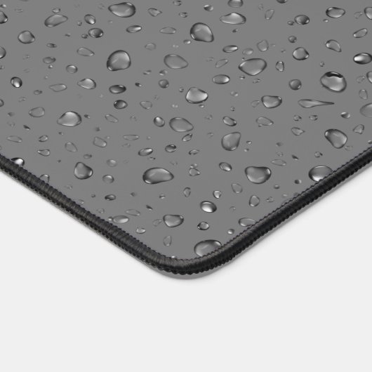 Regendruppels op donkergrijs bureaumat (Hoek)
