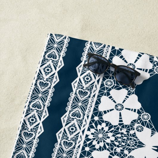 Retro wit kant met vlinders op een donkerblauwe b strandlaken (In situ)