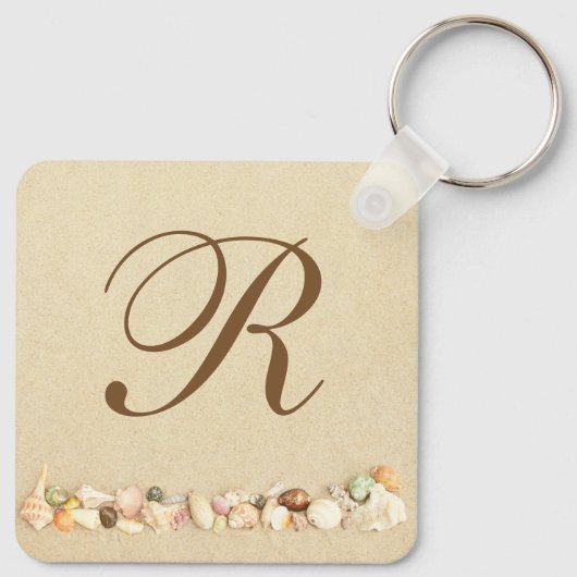 Rij zeeshells op strand zand met monogram sleutelhanger (Achterkant)