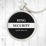 Ring Security Ring Bearer Sleutelhanger<br><div class="desc">Laat je ringdrager voelen als een geheim agent met deze stijlvolle zwart-witte "Ring Security" sleutelhanger. Het ontwerp is voorzien van een strak, agentstijl ontwerp dat zeker indruk zal maken. Perfect voor bruiloften, deze knop voegt een leuke en unieke touch toe aan uw speciale dag. Met zijn trendy en stijlvolle ontwerp...</div>