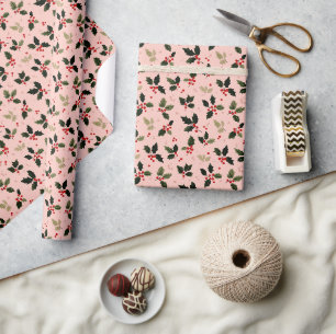 Rode bessen en hulst op roze cadeaupapier