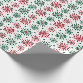 Rode en groene kerstsneeuwvlokken op wit cadeaupapier (Hoek)