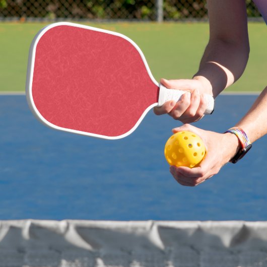 Rode gestructureerd oppervlak met subtiel draaiend pickleball paddle (Insitu)