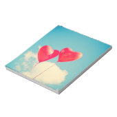 Rode hartballon tegen troebel hemd notitieblok (Linkerzijde)