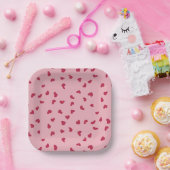 Rode hartjes verspreid over roze papieren bordje (Feest)
