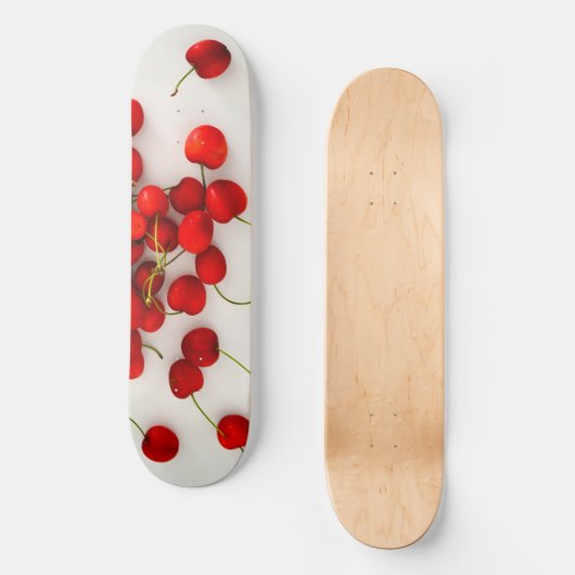 Rode kersen in natuurlijk licht liggen op wit persoonlijk skateboard (Voorkant)