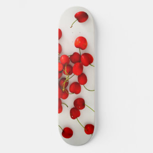 Rode kersen in natuurlijk licht liggen op wit persoonlijk skateboard