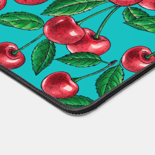 Rode kersen op turquoise bureaumat (Hoek)