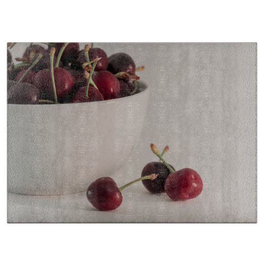 Rode kersenvruchten witte kom in gedempte tonen fo snijplank (Voorkant)