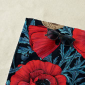 Rode klaprozen en wratten, blauwe bladeren op zwar strandlaken (In situ)