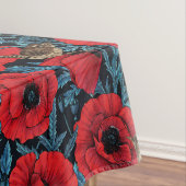 Rode klaprozen en wratten, blauwe bladeren op zwar tafelkleed (Voorbeeld)