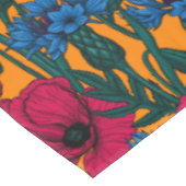 Rode papaver en blauwe cornbloemen op sinaasappel tafelkleed (Gekanteld)