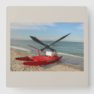 Rode reddingboot op het strand - herinneringen aan vierkante klok